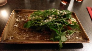 Bruschetta mit Tomaten und Mozarella, wenn man den Löwenzahn beiseite schiebt